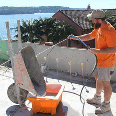 Man washing wheelbarrow with SLURRYTUB in use